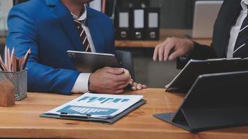 homme d'affaires travaillant avec un téléphone intelligent et un ordinateur portable et une tablette numérique au bureau avec des supports de marketing numérique dans une icône virtuelle video