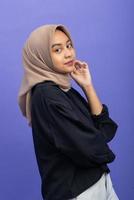 Asian Muslim Woman with Attractive Gesture on Purple Background photo