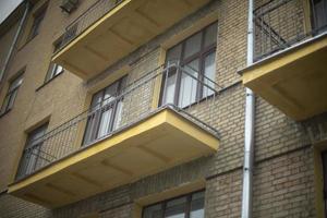 Open balconies. Balconies without glazing in house. Details of old house. Windows in brick wall. photo