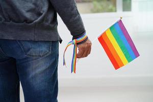 mujer asiática con bandera del arco iris, derechos de símbolos lgbt e igualdad de género, mes del orgullo lgbt en junio. foto