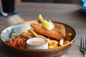 fried fish fellet wiht french fries and veggies on plate photo