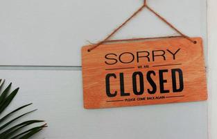 brown wooden signboard in front of wall photo