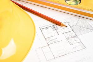 Architectural house plan project blueprint with yellow helmet and engineering construction tools. photo