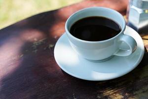 Hot black coffee in a white cup,coffee is a popular beverage all over the world. photo