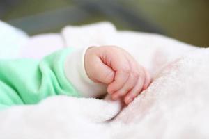 Closeup hand of infant child clenched into a fist. photo