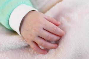 Closeup hand of infant child clenched into a fist. photo