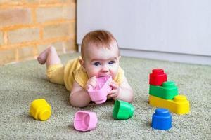 retrato sincero de estilo de vida de niña. niño pequeño jugando con un constructor colorido de plástico blando. foto