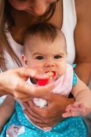 madre alimentando a su pequeña hija con puré de verduras de una cuchara. alimentación saludable nutrición para niños. foto