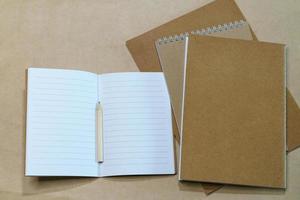 Blank white notepad and pencil on paper background. Mock up, top view, copy photo