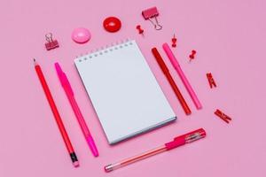 White notebook lies in the form of blank on pink background with red pen photo