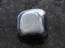 polished hematite stone on dark background photo