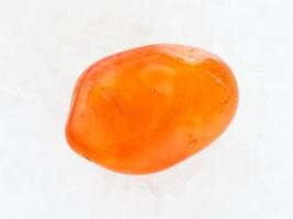 tumbled Carnelian gemstone on white marble photo