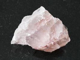 raw crystal of rose quartz gemstone on dark photo