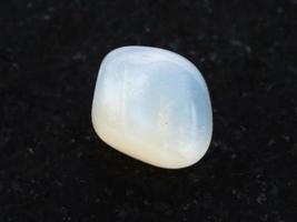 tumbled translucent moonstone gemstone on dark photo