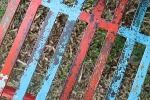enrejado de hierro con pintura roja y azul que se ha despegado foto