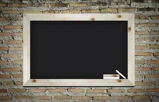 empty blackboard with wooden frame and chalks on wall background photo