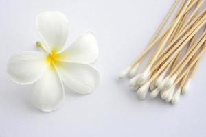 Cotton swab used for cleaning ear and Tropical flowers isolated on white photo