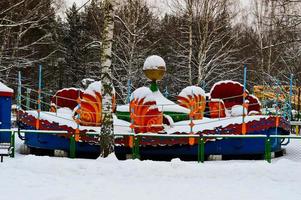 Empty snowy cold children's carousel, attraction in the park in winter photo