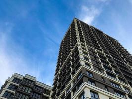 multi-storey building with many windows, brown and white decoration. black frames in the windows, panoramic glazing. a tall building for a happy and comfortable life for people photo