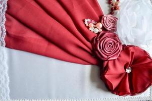 Red and white homemade flowers from a beautiful fabric decorated with rhinestones, pearls and beads. photo