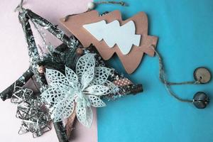 Festive New Year Christmas happy blue and pink beautiful joyful background with thinking small wooden and metal toy homemade tree and star. Flat lay. Top view. Holiday decorations photo