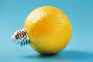 Lemon fruit as a light bulb on a blue background. The conceptual idea. photo