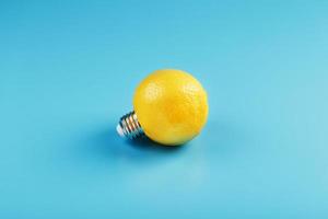 The light bulb is like a lemon on a blue background. photo