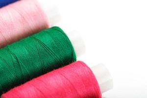 Sewing threads of different colors on reels on a white background. Free space, close-up. Isolate photo