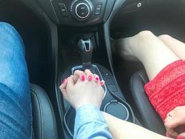 Guy man and woman girl in love holding hands in the car next to the gearbox. love road trip photo