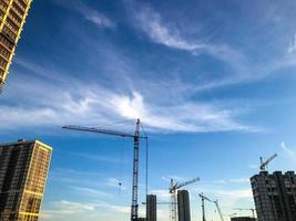 construction landscape, construction cranes and new houses. buildings made of concrete cellular blocks. creation of a new district in the city center. creating a comfortable environment photo