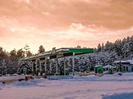 Beautiful small gas station for refueling cars with fuel, gasoline and diesel at sunset in the winter photo