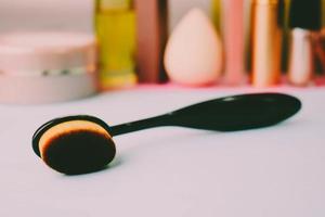 Wooden brush made of natural lint for applying tone on the background of a cosmetic table for makeup for beauty guidance photo