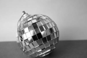 Silver mirror music club disco ball small round glass winter shiny decorative beautiful xmas festive Christmas ball, Christmas toy plastered on sparkles on a black and white background photo