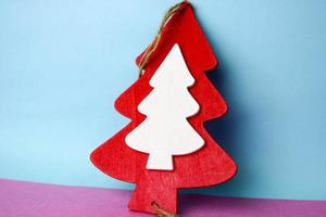 Festive New Year's Christmas beautiful bright multi-colored happy blue pink background with a small toy wooden homemade red and white cute Christmas tree. Holiday decorations photo