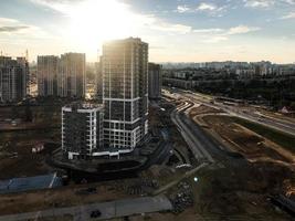 tall houses are in a new neighborhood. urban landscape. individual style of multi-storey buildings. next to the high-rise building is a highway for cars photo