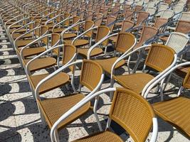 There are many outdoor light chairs in front of the amphitheater stage on the street for mass events and concerts photo