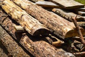 palos, tablas, troncos de madera con nudos y aserrín en el aserradero aserrado industrial de árboles. fondo, textura foto