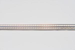 Strip LED light with aluminum profile on white stretch ceiling, modern construction, close up photo