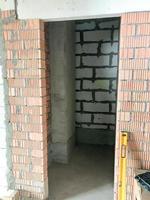 The doorway in the new building with a free plan, in an apartment without repair with walls of red brick and gas silicate blocks photo