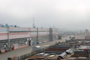 Industrial landscape. Panoramic view of the technological pipes. Rusty pipes, blue rubies, production communications. Repair buildings in production. Against the background of a misty sky photo