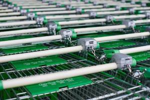Row of parked shopping carts of trolleys in supermarket photo