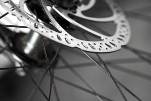 Bicycle disk brakes close up, metal disc attached to bike wheel, effective mountain bicycle brakes photo