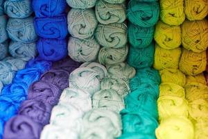 hilos o ovillos de lana en estantes en la tienda para tejer foto