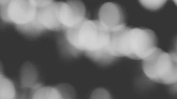 Blurred white Bokeh of light on black background in monochrome or black and white tone. Green lighting blurry wallpaper. photo