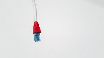 Local area network or LAN cable with red boot cover modular isolated on white background with copy space. RJ45 connector, communication wire and Technology of communication or Information technology photo