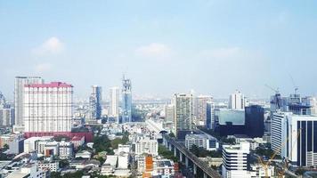 Landscape view of city with building, road or street and transportation of sky train or metro train with blue sky and cloud background with copy space on above. Panorama cityscape in Bangkok, Thailand photo