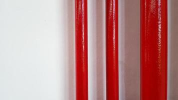 Big and and small red pipeline on white wall with copy space on right. Gas or water pipe and group of object. photo