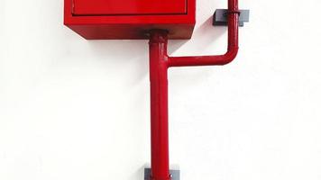 gabinete de acero inoxidable rojo y tubería de agua roja o gasoducto en pared blanca o papel tapiz. foto