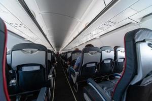 asientos de cabina de avión con pasajeros. clase económica de las nuevas aerolíneas de bajo costo más baratas. viaje viaje a otro país. turbulencia en vuelo. foto