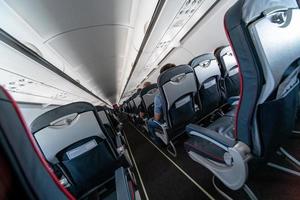 asientos de cabina de avión con pasajeros. clase económica de las nuevas aerolíneas de bajo costo más baratas. viaje viaje a otro país. turbulencia en vuelo. foto